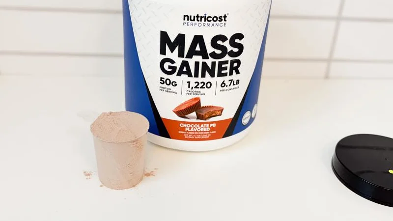 a full scoop of nutricost mass gainer next to the container 1