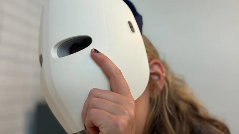 a-person-putting-on-the-theraface-mask-glo A person putting on the TheraFace Mask Glo.