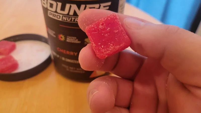 A hand holds a Bounce Nutrition Creatine Gummy.