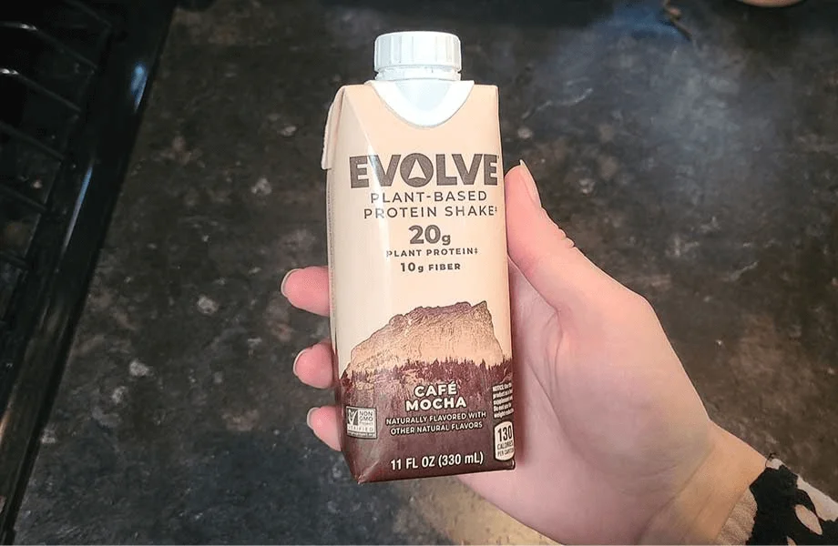 Our tester holding a single carton of Evolve Plant-Based Protein Shake