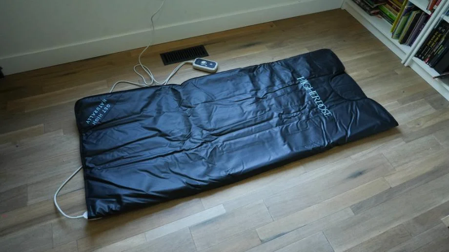 The HigherDOSE Infrared Sauna Blanket rolled out on a floor