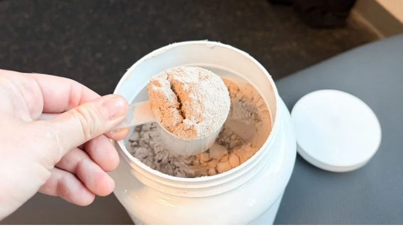 Our tester holding a scoop of 1st Phorm Level-1 Natural protein powder to demonstrate a serving size.