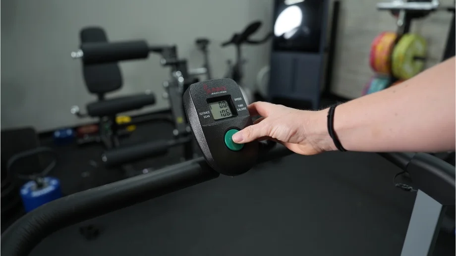 sunny health and fitness manual treadmill close up pressing green button on screen controls copy