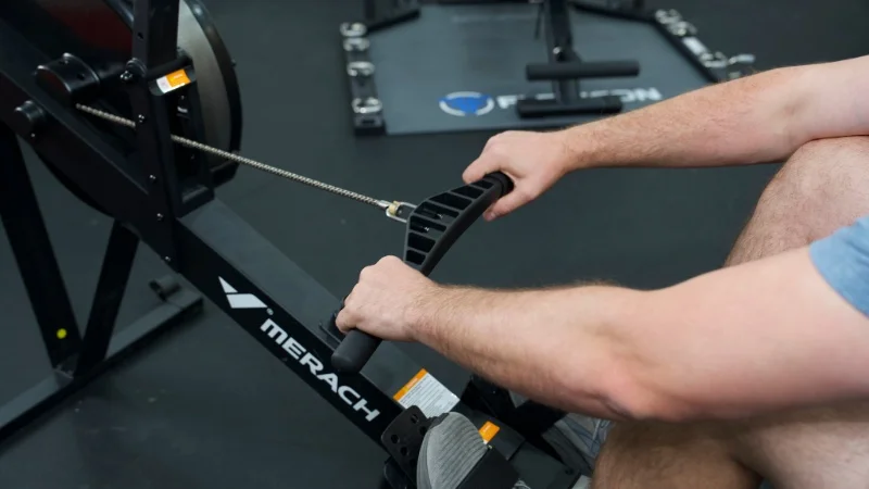 Looking at the handles of a MERACH NovaRow R50 while a person is rowing
