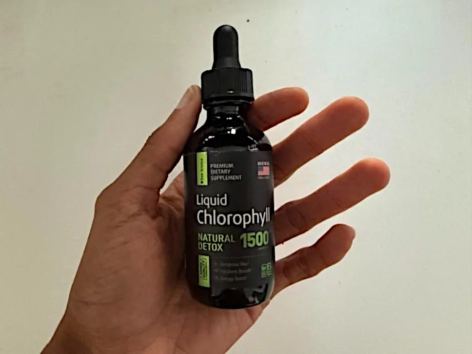 Our tester holds up a bottle of Raw Science Liquid Chlorophyll