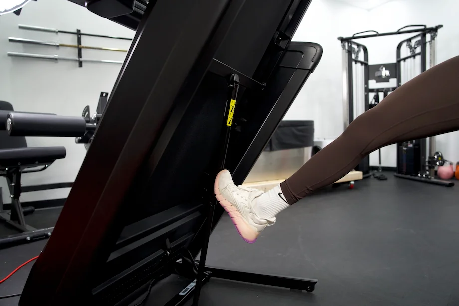 Product tester folding up the NordicTrack 1750 Commercial treadmill