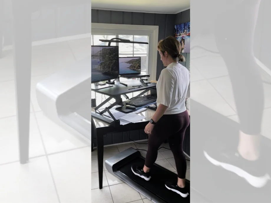 A woman walks on a WalkingPad treadmill in an office