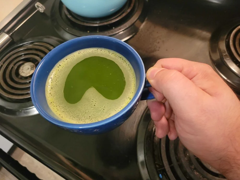 Our tester holdinga cup of Naoki Superior Blend Matcha