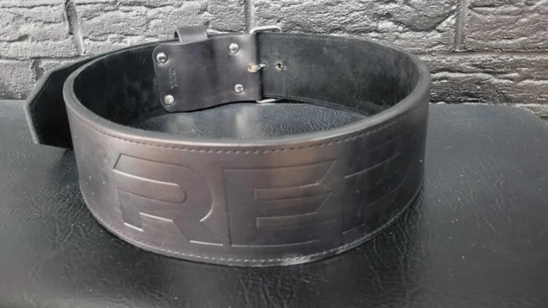 The REP USA Premium Leather Lifting Belt on a weighlifting bench.