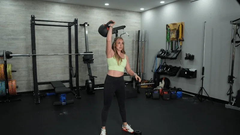 Our tester holding the REP Fitness Adjustable Kettlebell in an overhead racked position