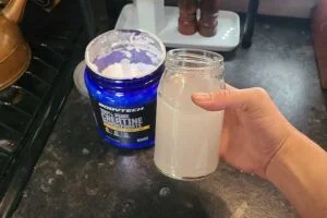 someone holding a glass of bodytech creatine