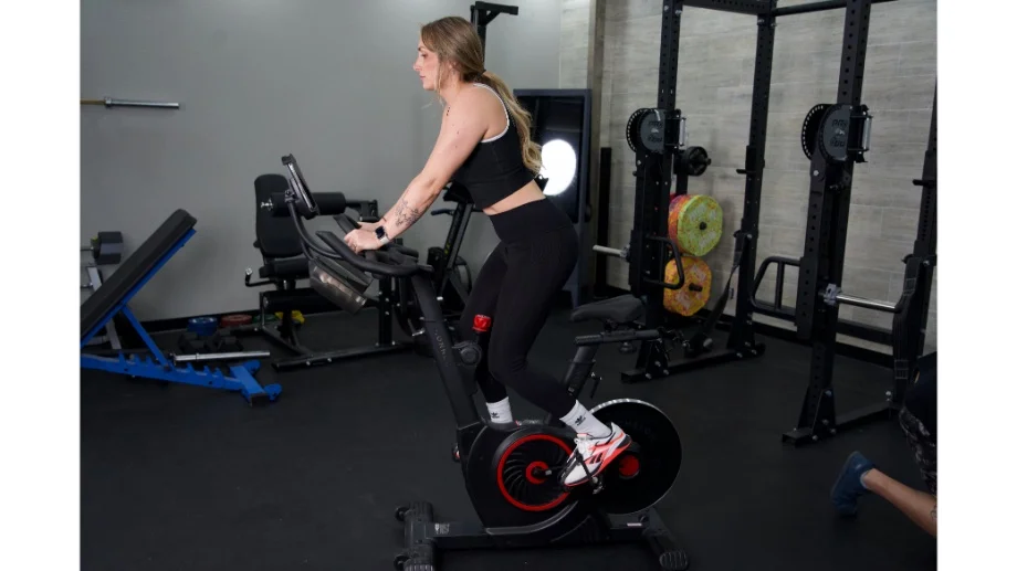 woman standing up riding the echelon ex5 bike