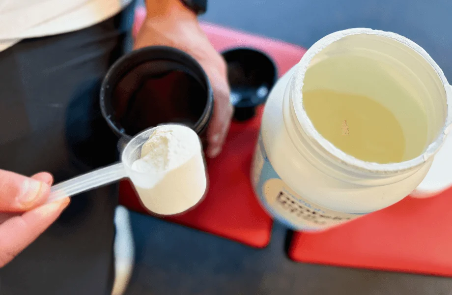 Our tester adding a scoop of Wellah Protein Your Whey protein powder to their shaker cup