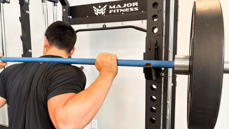 Our tester racking a barbell into the Major Fitness B52 Pro's J-hooks