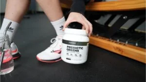 transparent labs prebiotic greens holding container front of container