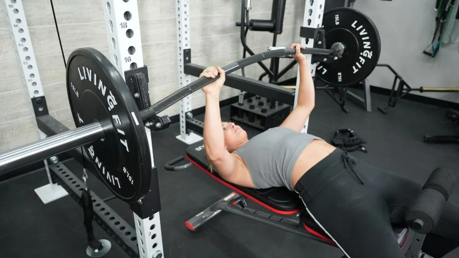 Woman benching with Vulcan Buffalo bar