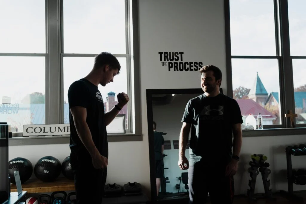 A personal trainer coaching a man in a gym