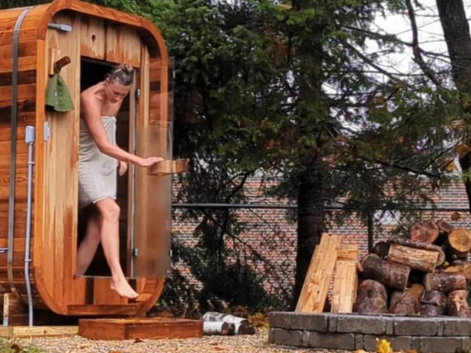 A woman walking out of the Redwood Outdoors Duo Sauna