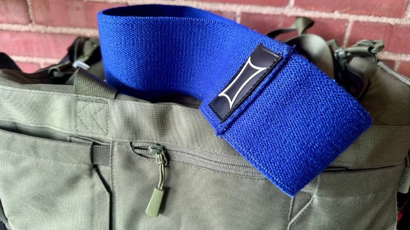 A Mark Bell Sling Shot Hip Circle on top of a gym bag
