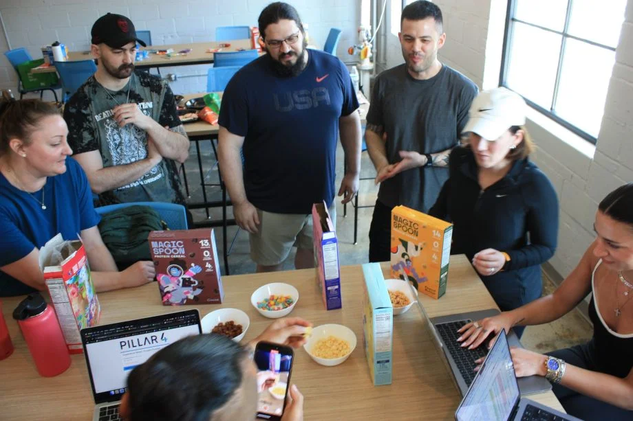 The Garage Gym Reviews team stands around a table sampling Magic Spoon Cereal