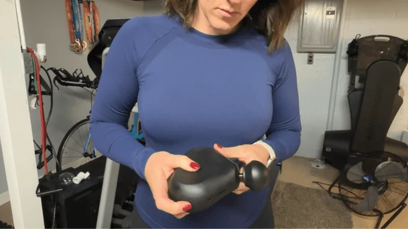 Our tester powering on the Therabody Theragun Mini before a massage session