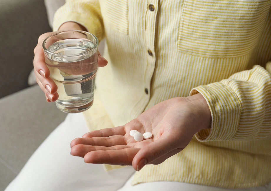 woman-taking-calcium-supplement-with-water