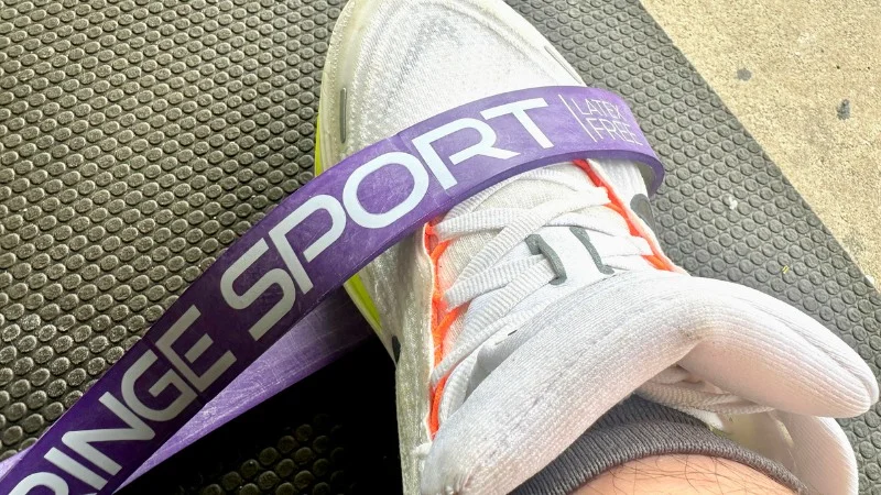 A Fringe Sport Latex-Free Strength Band draped over a training shoe