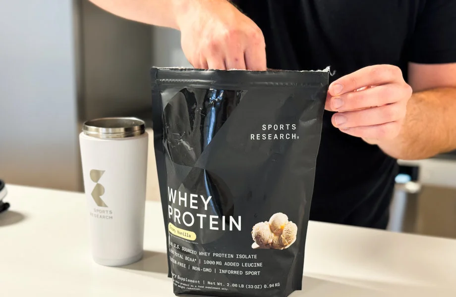 Reaching into a bag of Sports Research Whey Protein