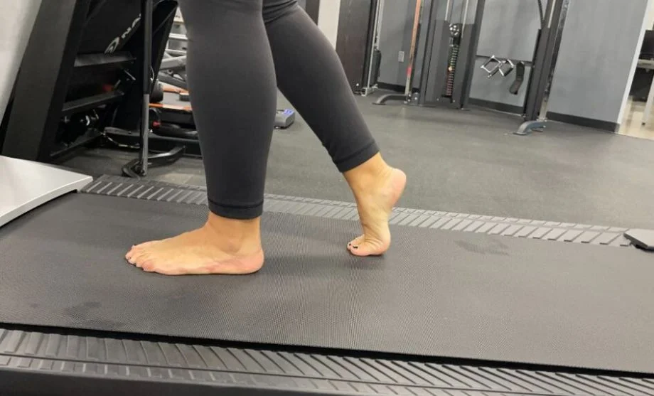 Close up view of someone's bare feet while walking on a treadmill