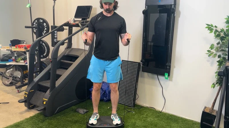 Our product tester squats with resistance bands on a Softgym Vibration Plate