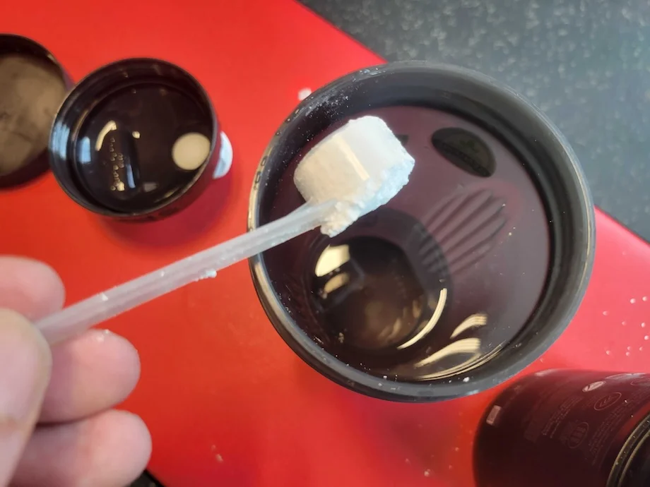 Person scooping Sports Research Creatine Monohydrate into a shaker cup