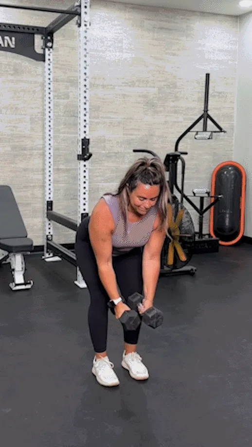 Woman performing a standing dumbbell reverse fly