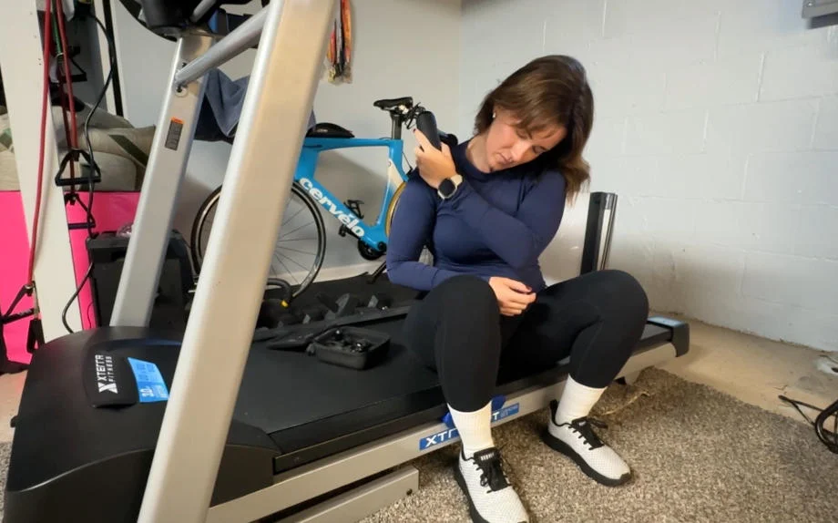 A woman uses the Bob & Brad Q2 Mini Pro on her trap muscles.