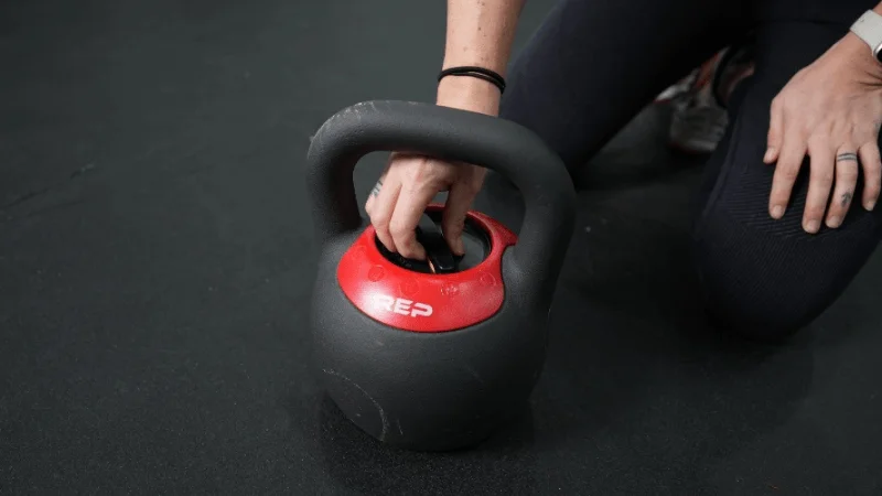 Our tester locking the adjustable REP Fitness Adjustable Kettlebell weights into place before a workout