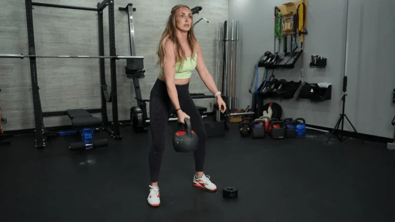 Our tester swinging the REP Fitness Adjustable Kettlebell to their shoulders