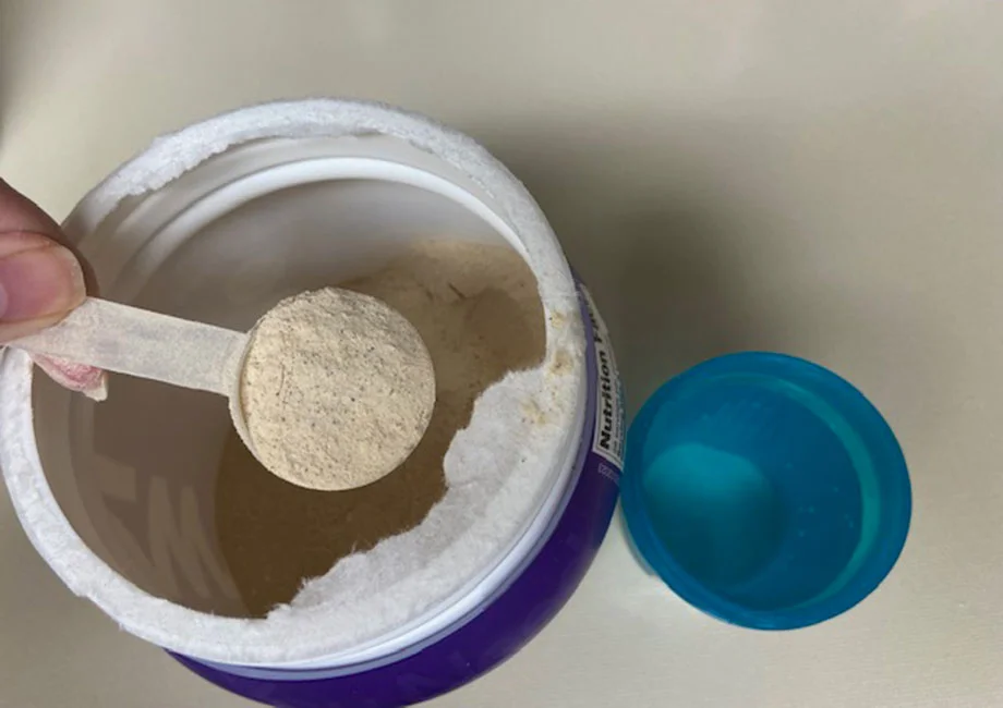 Scooping up some OWYN Protein Powder.