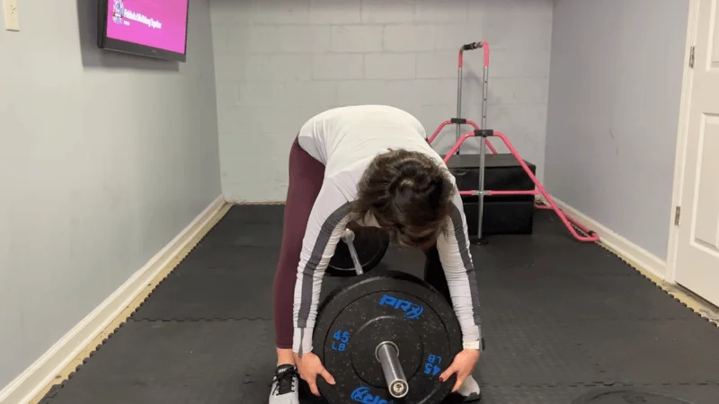 Our tester loading a PRx Crumb Rubber Bumper Plate onto a barbell