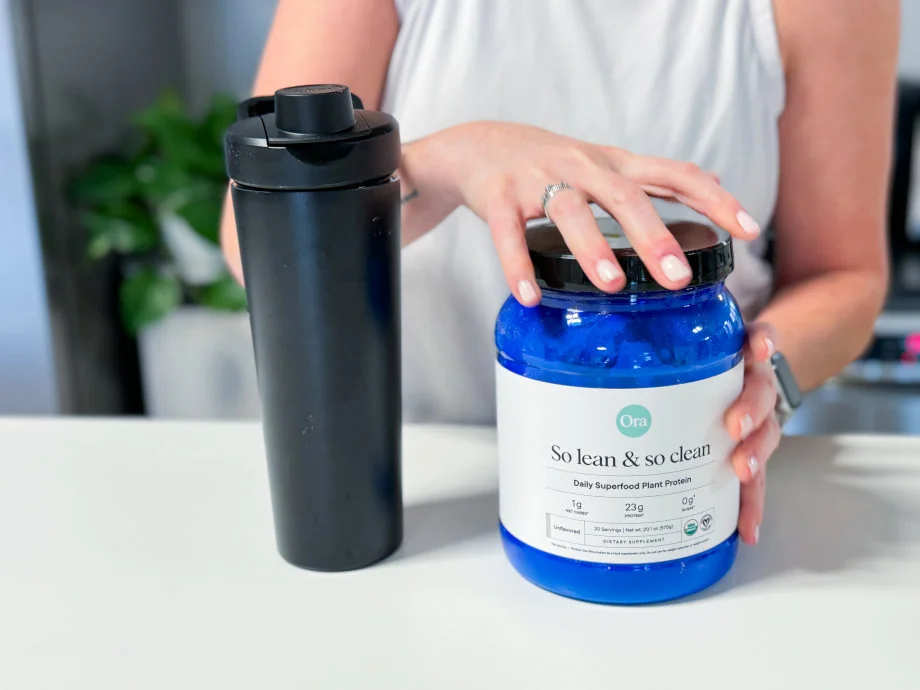 Our tester opening a container of Ora Organics So Lean & So Clean Plant Based Superfood Protein