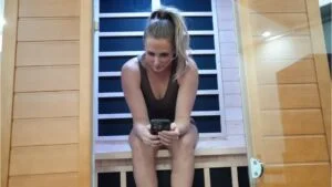 dynamic sauna dynamic andora infrared sauna sitting in sauna on phone