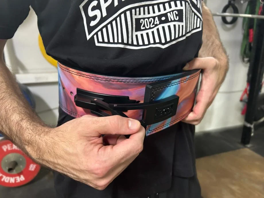 A man securing the Bells of Steel lever Belt around his waist