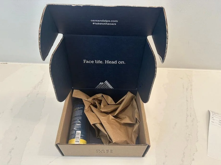 Looking down into a freshly-opened box of Oars + Alps Aluminum-Free Deodorant Spray.