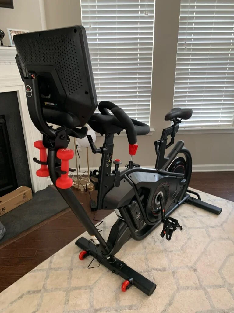 View of a peloton alternative, the bowflex velocore bike from front in a small home workout space