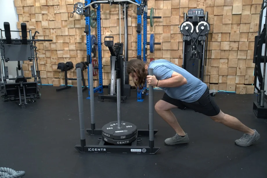Side view of our tester pushing a Centr x HYROX Competition Power Sled