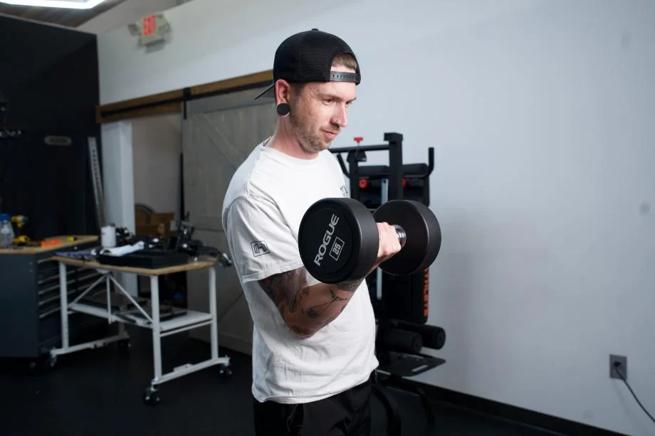 A man doing curls with a Rogue Urethane Dumbbell