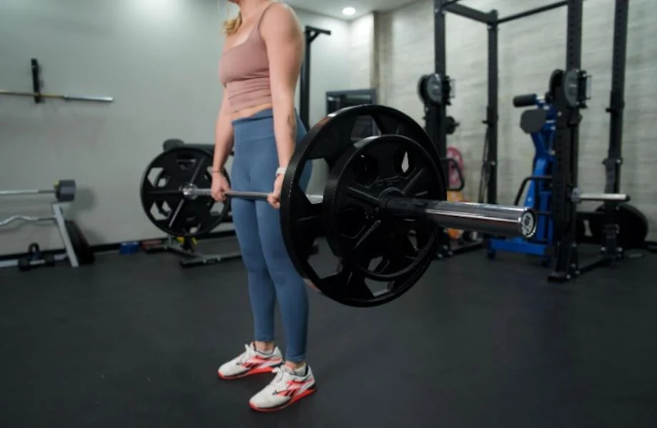 Side view as a woman lifts with the Major Fitness Barbell