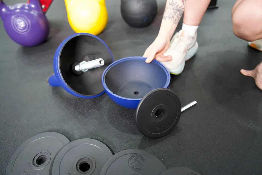 A woman assembling the Bells of Steel Adjustable Kettlebell