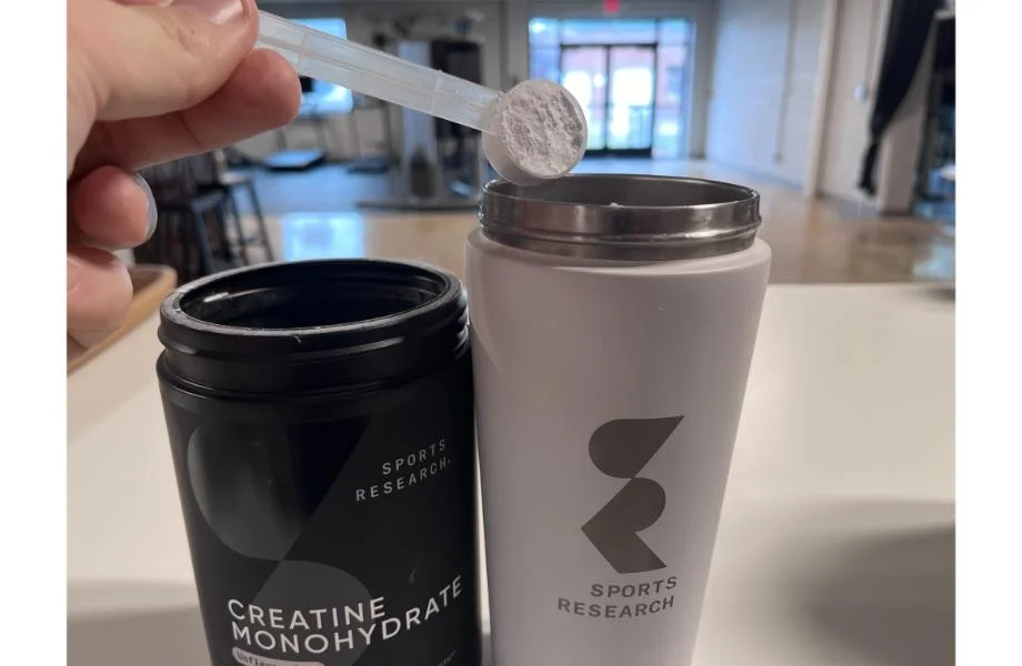 scooping_sports_research_creatine_monohydrate_into_cup