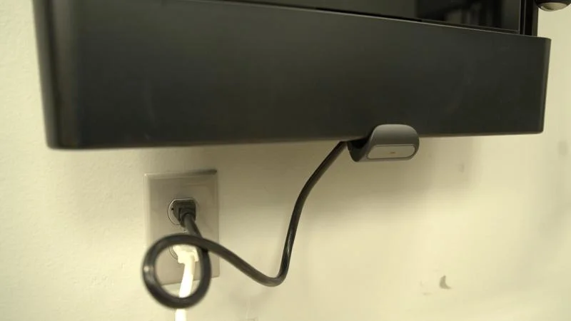 A Tonal 2 Smart Home Gym is plugged into an outlet with a black cord