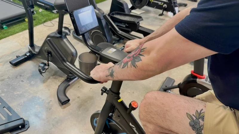 Product tester holding onto the handlebars of the Merach S39 bike