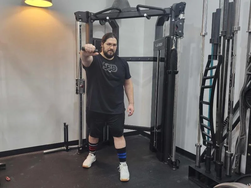 Our tester performs standing chest presses on the XMark Functional Trainer.&nbsp;